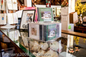 Jim Gibson's solo piano CDs displayed on a counter in a gift shop.