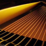 Golden bass strings inside a big Yamaha grand piano