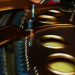 Photo of inside a grand piano--strings, pins, soundboard